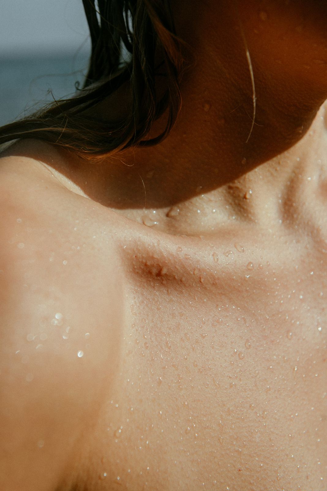 Close-up of wet skin and damp hair on a shoulder